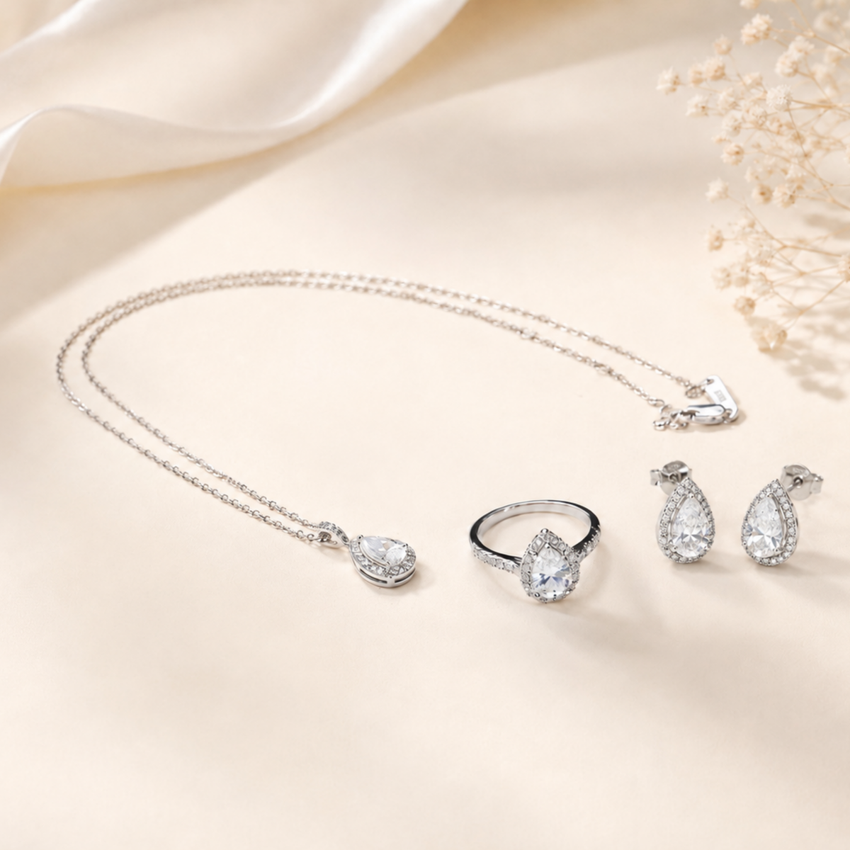 Lumière Pear jewelry set with matching pear-cut moissanite necklace, stud earrings, and halo ring by Avelune Collection.