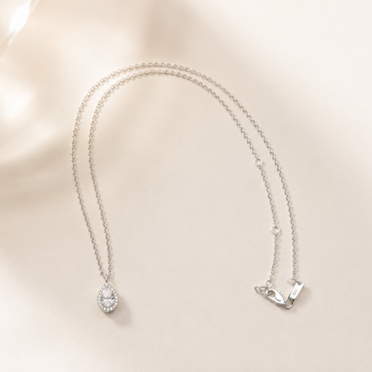 Lumière Pear moissanite pendant necklace in rhodium-plated sterling silver by Avelune Collection.