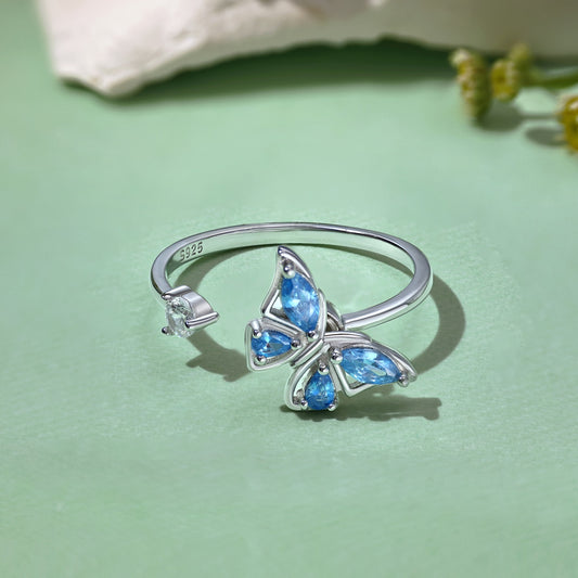 Sterling silver fidget ring with rotating blue butterfly and clear stone accent