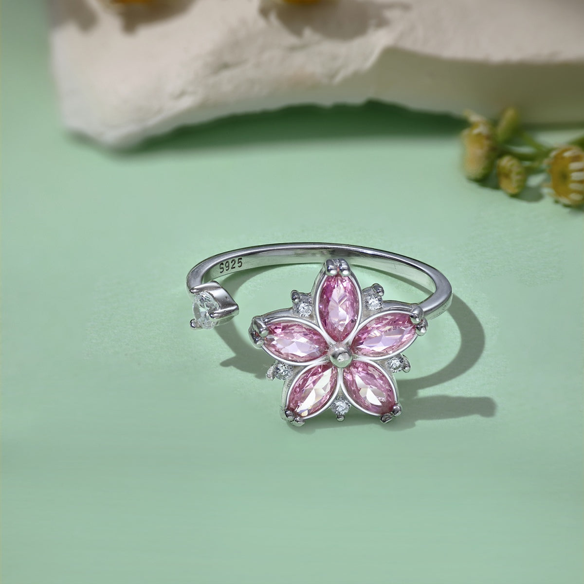 Sterling silver fidget ring with rotating pink flower and clear stone accents